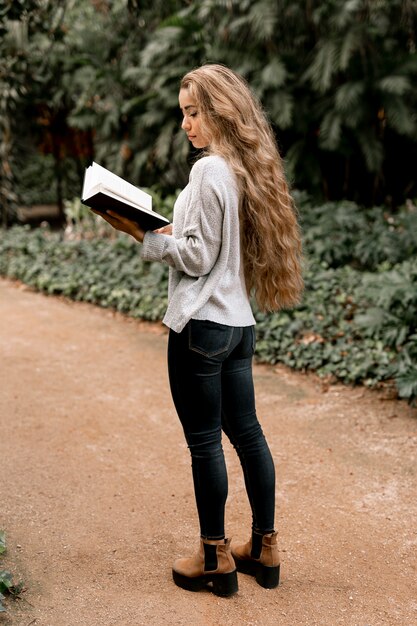 야외에서 책을 읽고 아름 다운 젊은 여자
