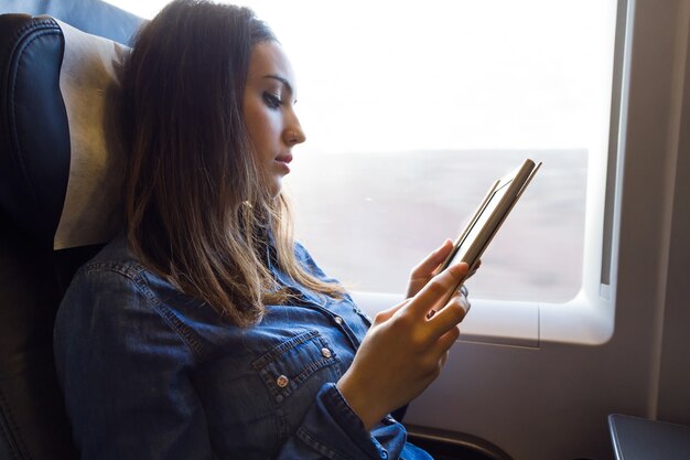 列車で本を読んでいる美しい若い女性。