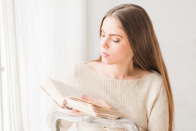 Foto gratuita libro di lettura della bella giovane donna