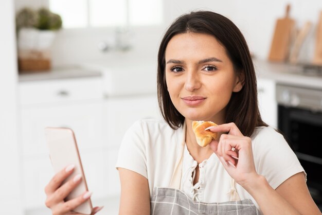 美しい若い女性はクロワッサンを食べる準備ができて