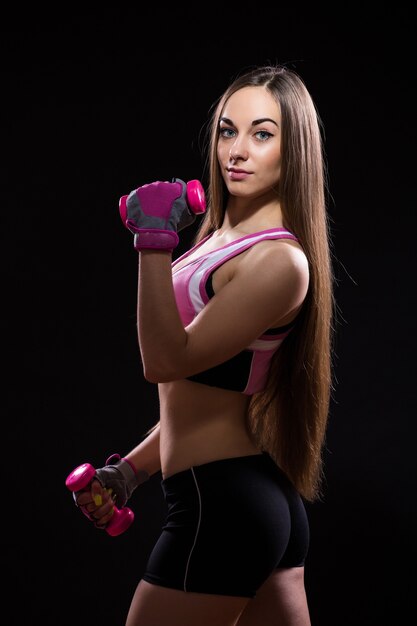 Beautiful young woman in a red boxing gloves isolated over black background