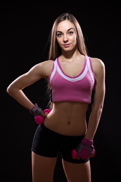 Beautiful young woman in a red boxing gloves isolated over black background