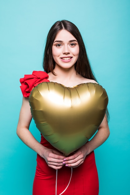 Free photo beautiful young woman in red dress with heart shape air balloon. woman on valentine's day. symbol of love