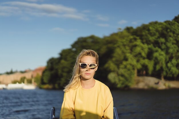 beautiful young woman in a red raincoat rides a private yacht. Stockholm, Sweden