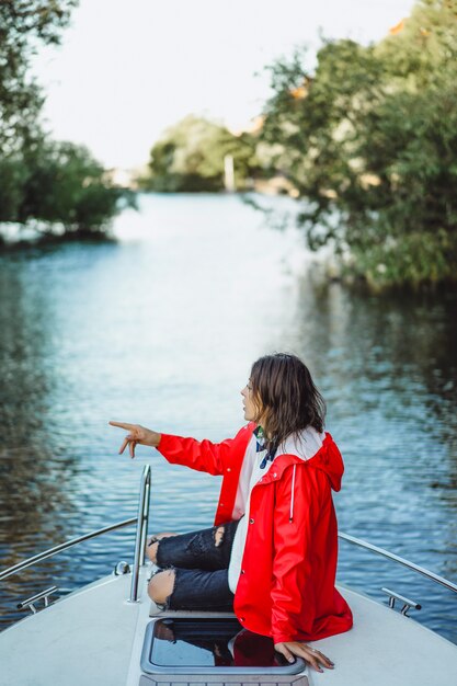 赤いレインコートを着た美しい若い女性は、プライベートヨットに乗る。スウェーデンのストックホルム