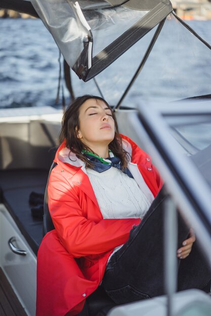 赤いレインコートを着た美しい若い女性は、プライベートヨットに乗る。スウェーデンのストックホルム