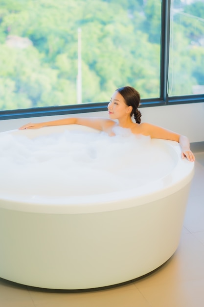 Free photo beautiful young woman relaxing in bathtub