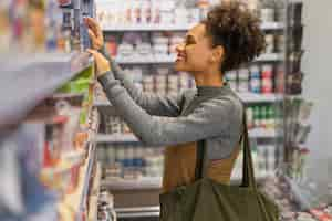 Free photo beautiful young woman shopping for food