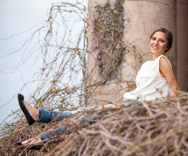 Beautiful young woman sitting in a vine