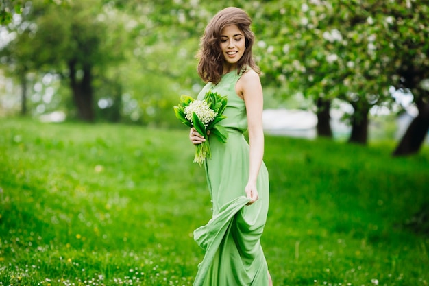 Free photo beautiful young woman standing in a green garden