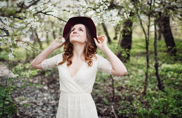 咲く木の近くに立つ美しい若い女性
