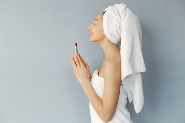 Beautiful young woman standing with lipstick