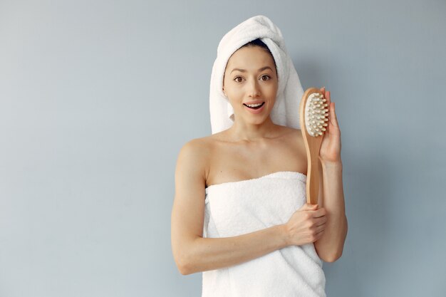 マッサージブラシで立っている美しい若い女性