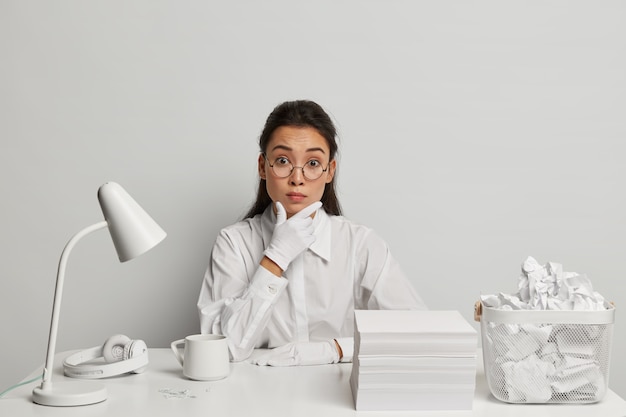 Bella giovane donna che studia alla sua scrivania