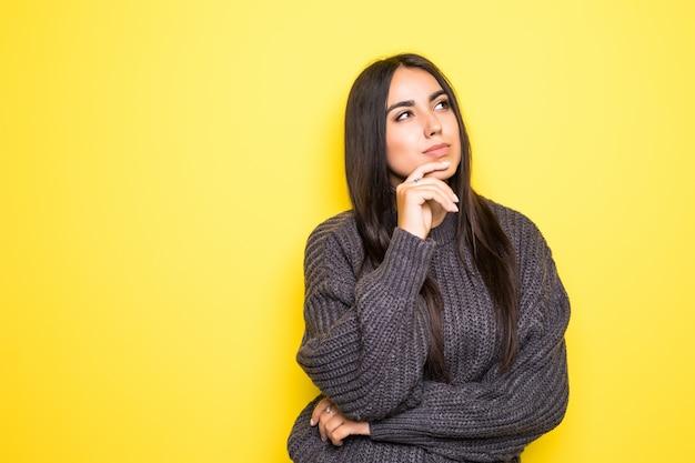 Beautiful young woman sweater smiling, and on yellow.