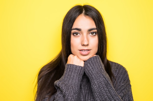 Beautiful young woman sweater smiling, and on yellow.