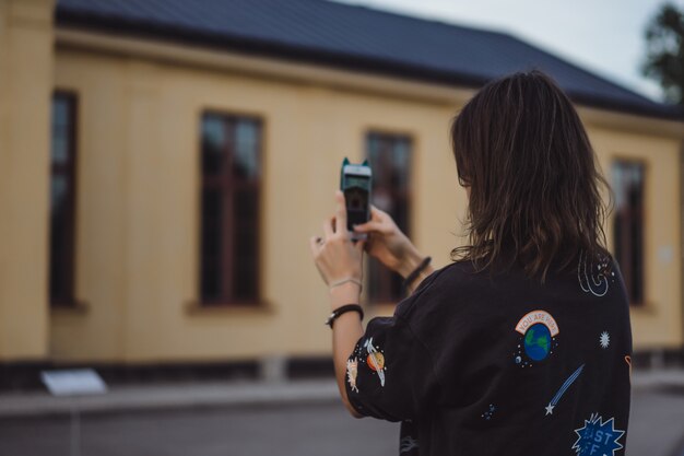 beautiful young woman taking pictures on a smartphone