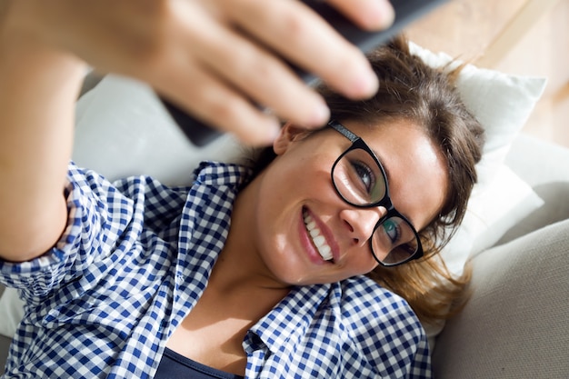 아름 다운 젊은 여자 집에서 selfie를 복용.