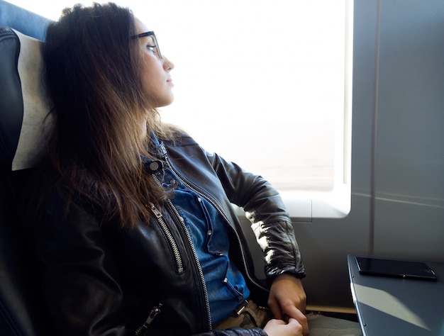 Foto gratuita bella giovane donna che viaggia in treno.