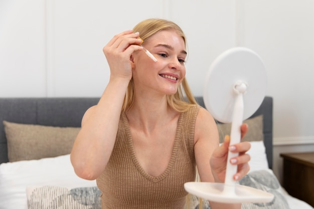 Beautiful young woman using a face care oil