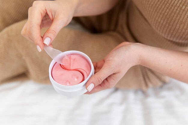 Beautiful young woman using a face care product