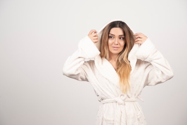 Free photo beautiful young woman in a white bath robe isolated on white background .