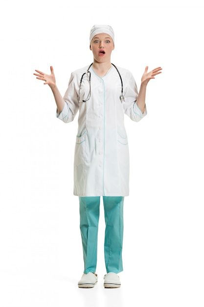 Beautiful young woman in white coat posing at studio. Full length studio shot isolated on white.