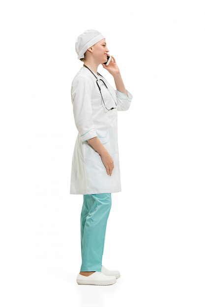 Beautiful young woman in white coat posing talking on the phone