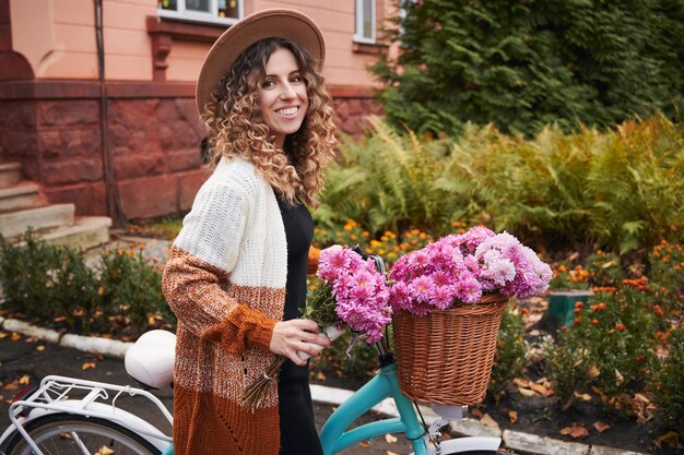 거리에 자전거가 서 있는 아름다운 젊은 여성