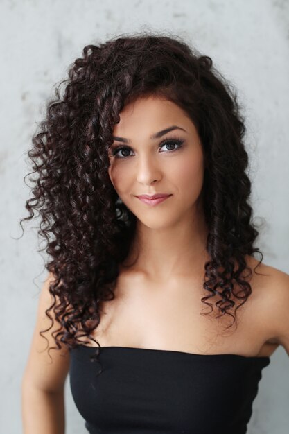 Beautiful young woman with black curly hair