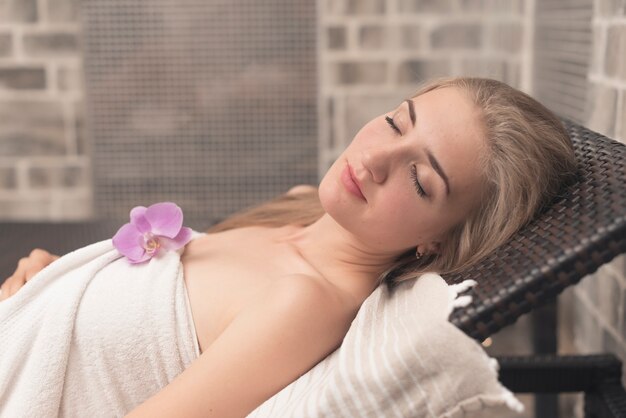 Beautiful young woman with eye closed sleeping on lounge chair