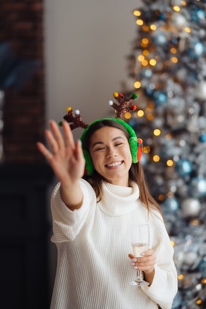 Bella giovane donna con un bicchiere di champagne a casa