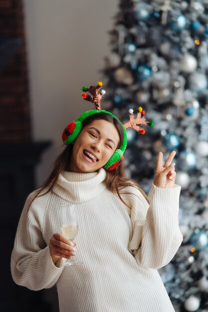 Free photo beautiful young woman with glass of champagne at home