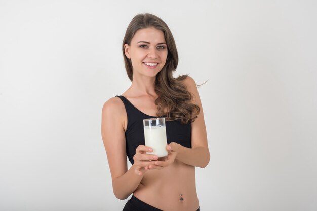 Красивая молодая женщина со стеклянным молоком