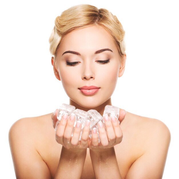 Beautiful young woman with ice in her hands. Skin care concept. Isolated on white.