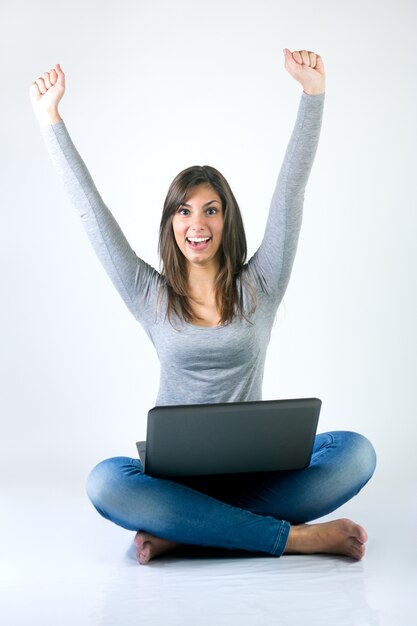 Beautiful young woman with laptop in studio