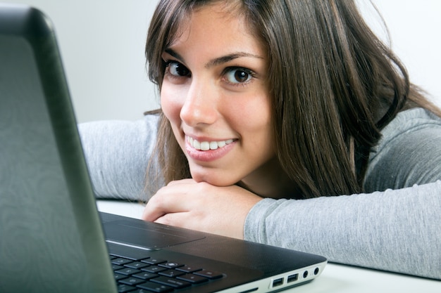 Beautiful young woman with laptop in studio