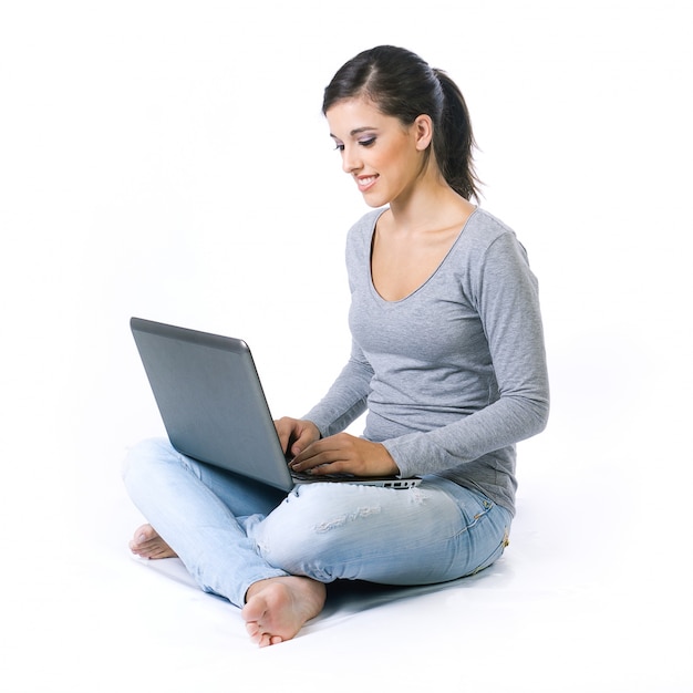 Beautiful young woman with laptop in studio