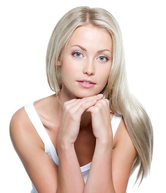 Foto gratuita bella giovane donna con lunghi capelli lisci su un muro bianco