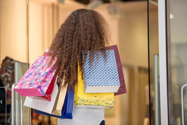 Bella giovane donna con i sacchetti della spesa nel centro commerciale