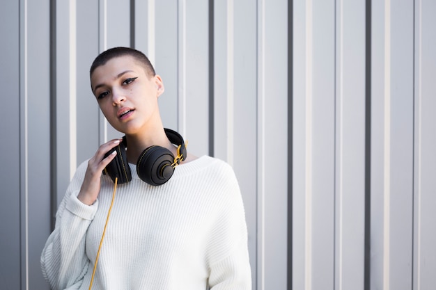 Beautiful young woman with short hair and wired headphones