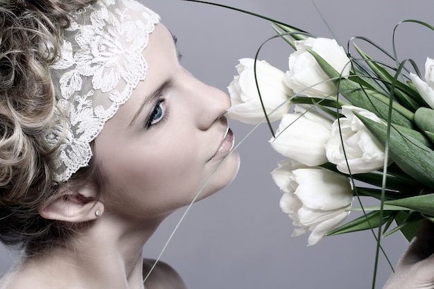 Free photo beautiful young woman with white tulips