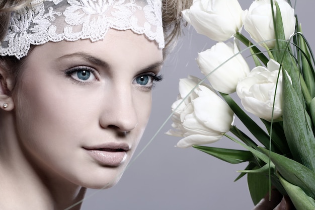 Красивая молодая женщина с белыми тюльпанами