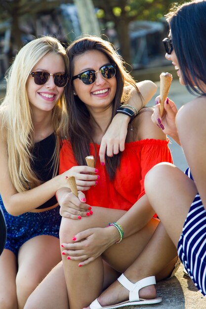 Beautiful young women having fun with ice cream at the park.