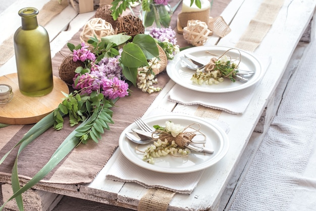 Beautifully elegant decorated table for holiday with modern cutlery, bow, glass, candle and gift