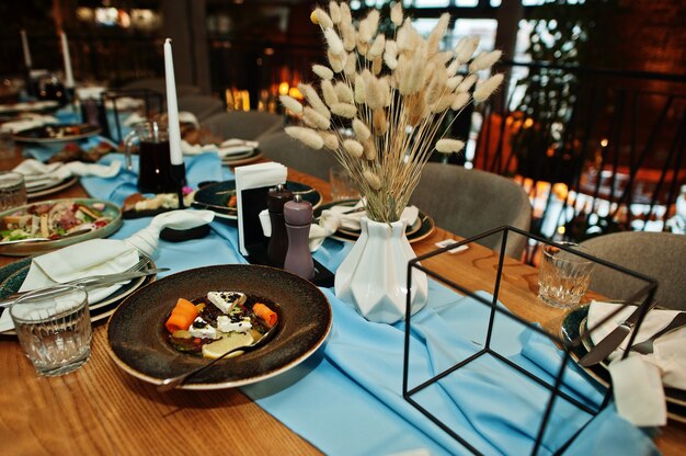 レストランで食べ物、グラス、電化製品を備えた美しく置かれたテーブル。 Premium写真
