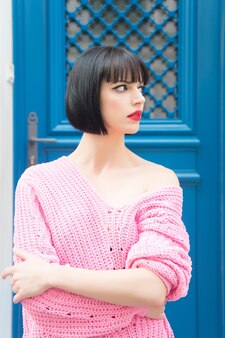 美しさとファッション、スタイリッシュな短いブルネットの髪と青い背景、フランスの屋外で赤い唇を持つパリの女性