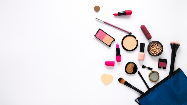 Beauty bag with different cosmetics on white table