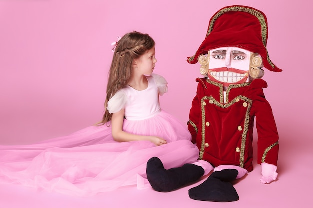 Free photo beauty ballerina with nutcracker on pink