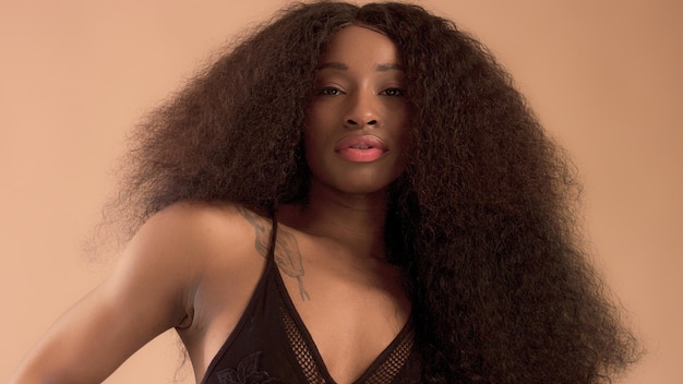 Donna afroamericana nera di razza mista di bellezza con lunghi capelli ricci e sorriso perfetto